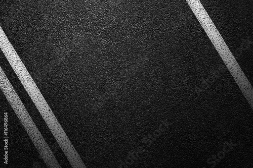 Level asphalted road with a dividing white stripes. The texture of the tarmac, top view.