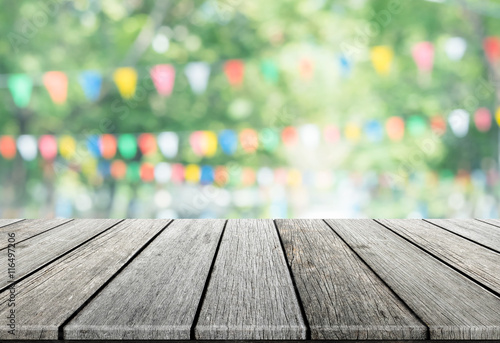 Empty wooden table with party in garden background blurred.