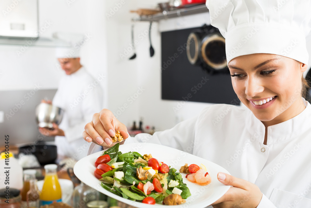 Woman chef serving fresh salad