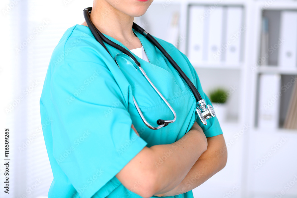 Female surgeon doctor is standing with arms crossed at hospital. Physician is ready to examine patient Female surgeon doctor is standing with arms crossed at hospital. Physician is ready to examine patient