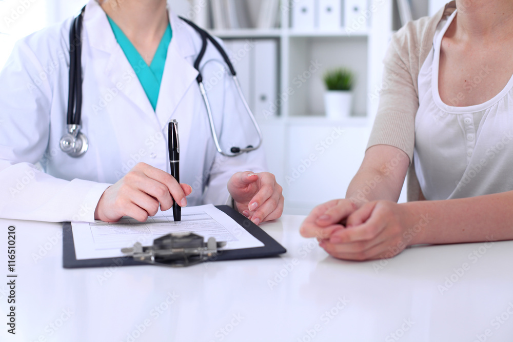 Doctor and patient are discussing something, just hands at the table Doctor and patient are discussing something, just hands at the table