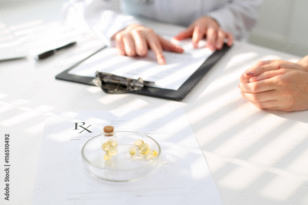 Fototapeta premium Medicine capsules and pills are lying against the background of a doctor and patient