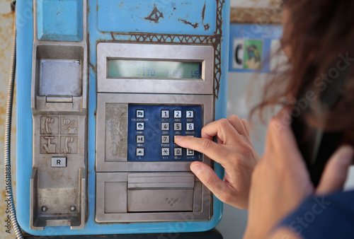 mujer llamando en cabina telefónica