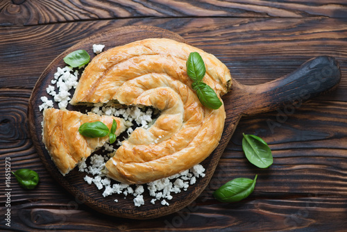 Above view of baked burek pie in a rustic wooden setting photo