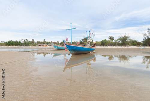 Wooden fishing boat on the low tide beach.