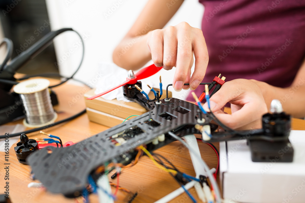 Woman assembler the parts on drone body Woman assembler the parts on drone body