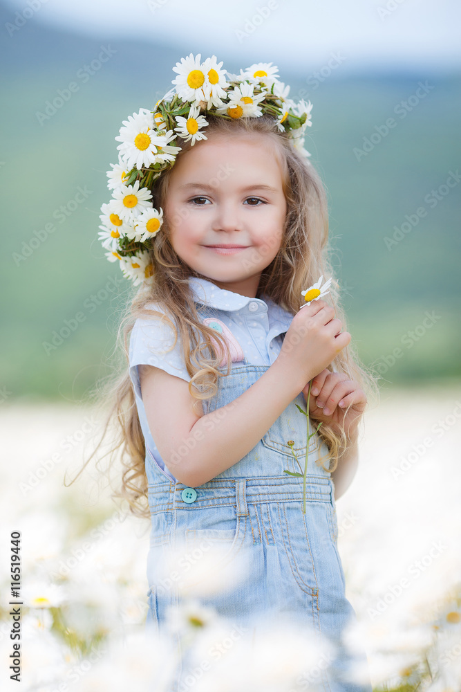 Beautiful little girl with long curly blond hair,cute smile,light