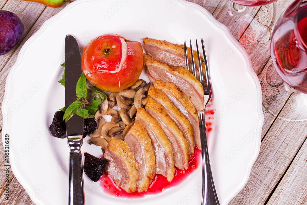 Duck breast with apple, smoked plums, mushrooms and basil in red wine sauce. View from above, top studio shot Duck breast with apple, smoked plums, mushrooms and basil in red wine sauce. View from above, top studio shot