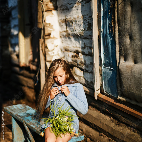 Beautiful girl posing with big bouquet of wild flowers © polinariaegorova