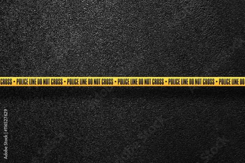 Yellow police line in the background smooth asphalt road. Do not cross. The texture of the tarmac, top view.