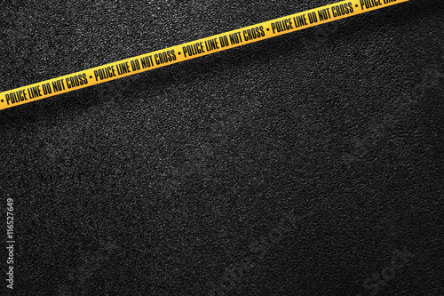 Yellow police line in the background smooth asphalt road. Do not cross. The texture of the tarmac, top view.