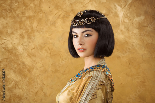 Obraz na plátně Beautiful Egyptian woman like Cleopatra on golden background