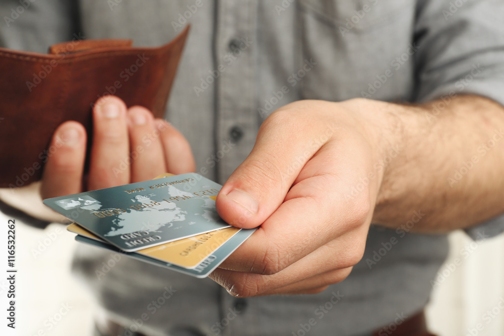 Man holding wallet with credit cards, closeup Man holding wallet with credit cards, closeup