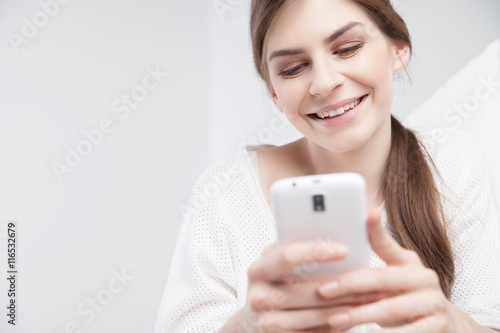 Happy young brunette using cell phone