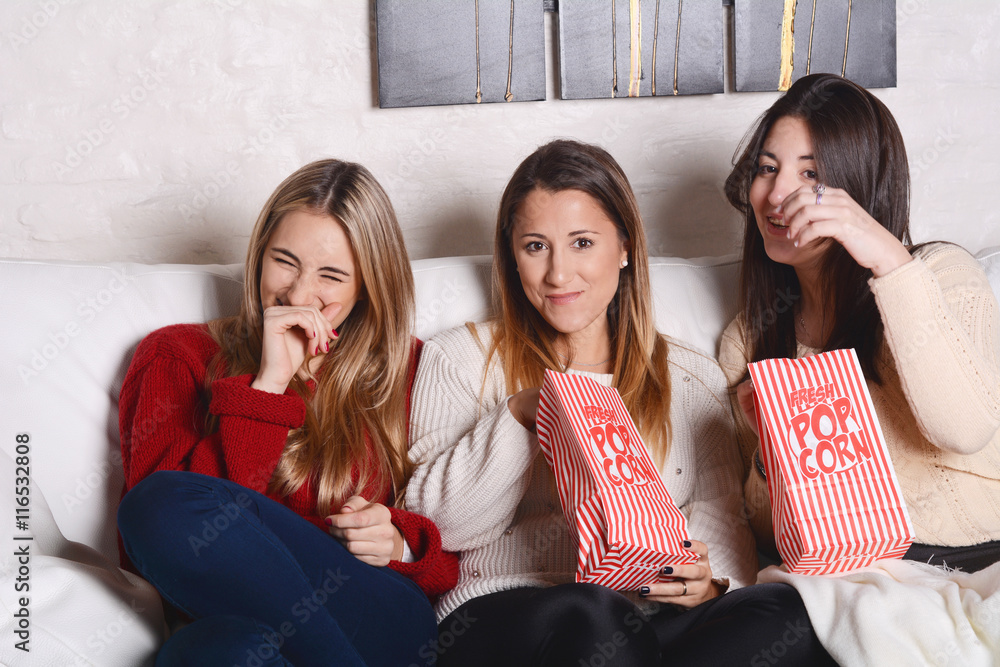 Three young friends eating popcorn and watching movies. Three young friends eating popcorn and watching movies.