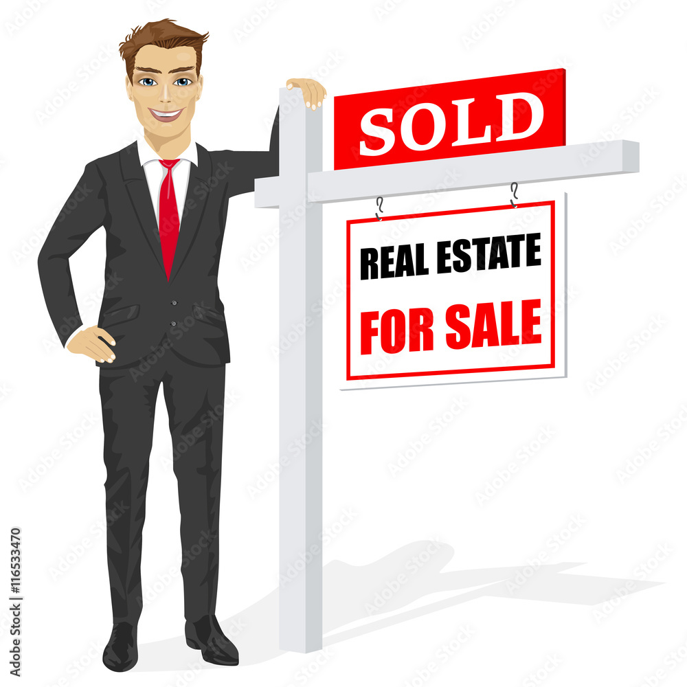 Male real estate agent standing next to a sold for sale sign Stock ...