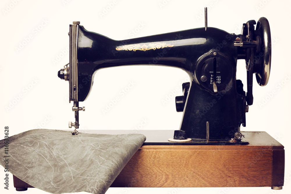 Retro sewing machine and gray leather isolated on white. Front view.