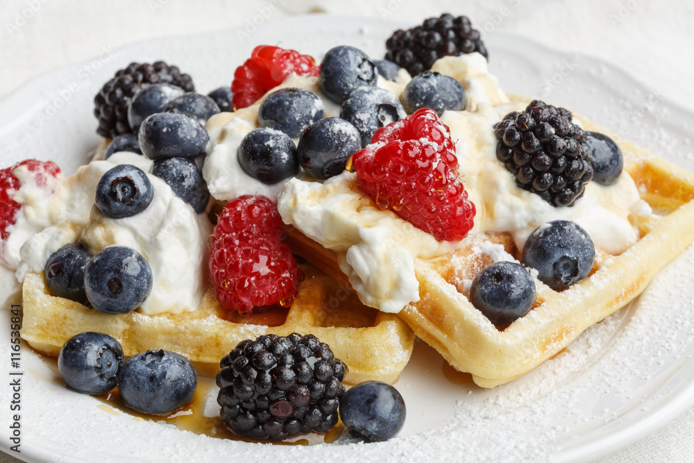 Belgian waffles with whipped cream and berry fruits Belgian waffles with whipped cream and berry fruits