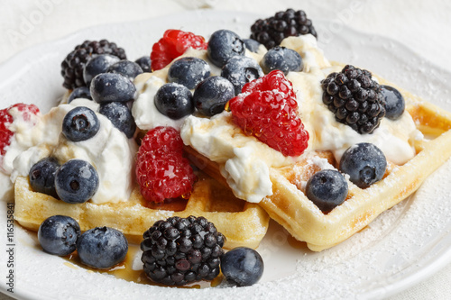 Belgian waffles with whipped cream and berry fruits