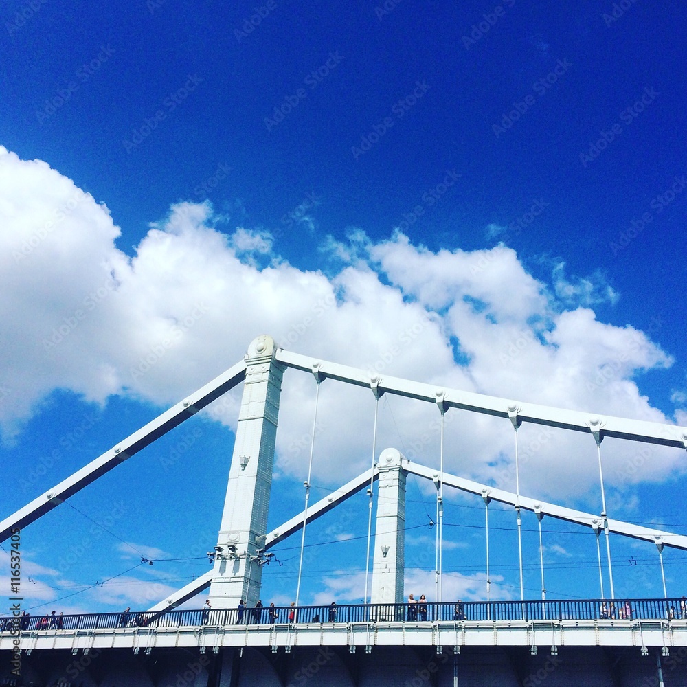 Obraz premium Большой белый мост на фоне голубого неба и облаков.