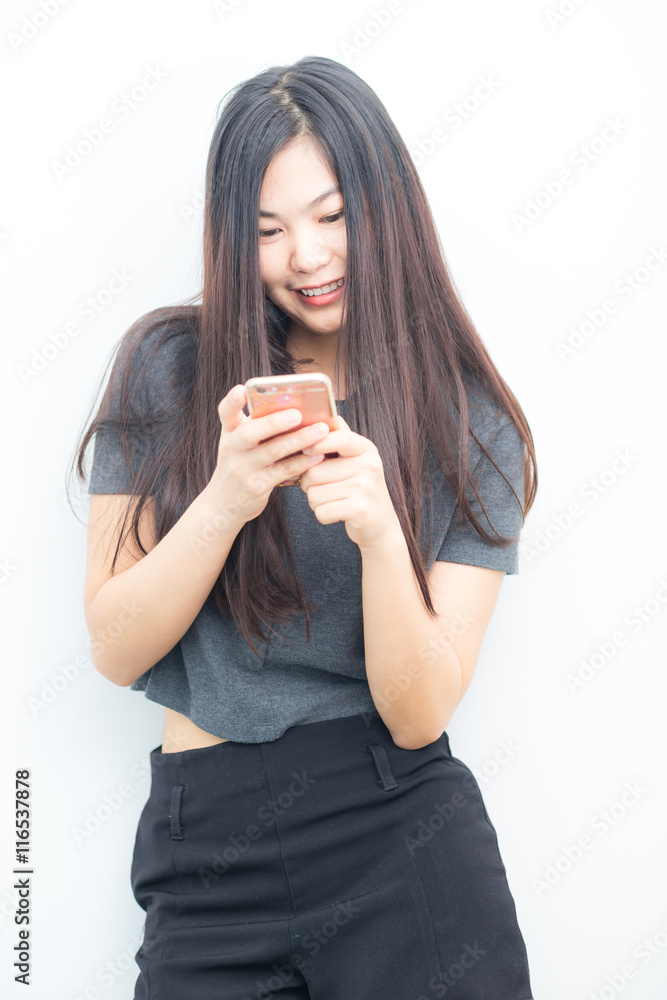 Smiling asian charming woman is using on smartphone texting Smiling asian charming woman is using on smartphone texting
