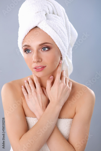 Beautiful woman with a towel on her head on a gray background