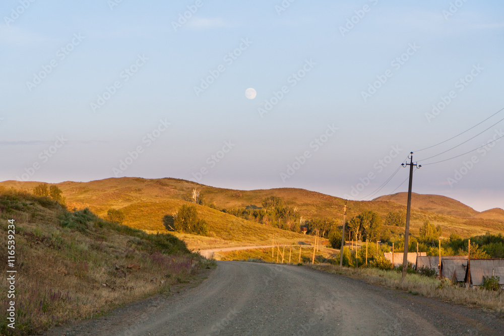 The road among hills and trees sunny summer day.