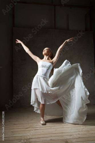 Beautiful ballet dancer in white costume with waving skirt dancing