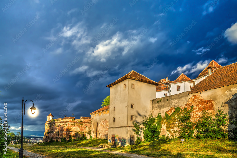 Sunset light with clouds storm at Old Fortress Cetatuia in Brasov, Transylvania, Romania