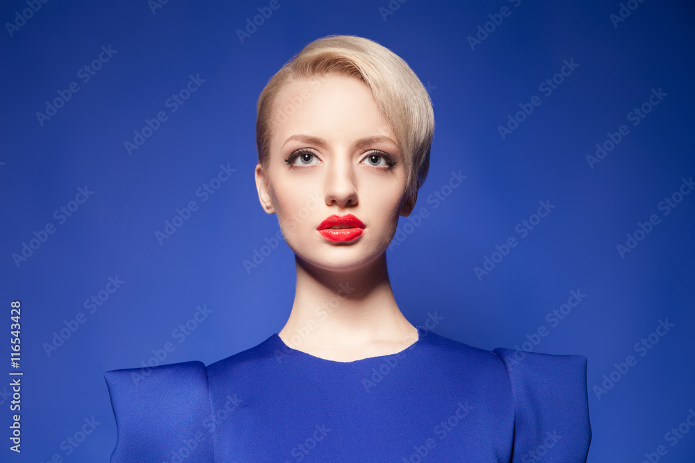Pretty blonde model with fashion hairstyle against of blue backgound Pretty blonde model with fashion hairstyle against of blue backgound
