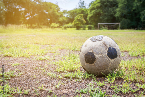 Old football on the field and small gravel