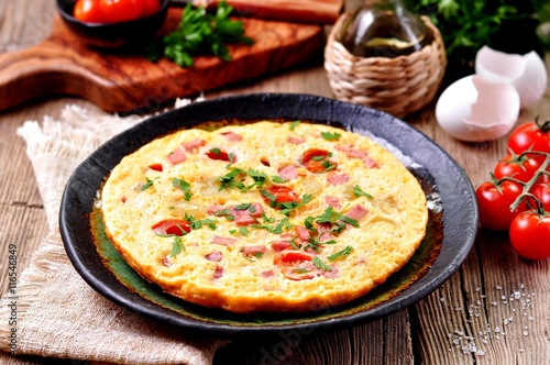 Scrambled eggs with ham, tomato and parsley