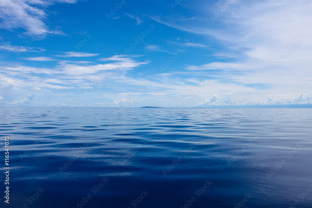 Photo of Blue Sea and Tropical Sky Clouds. Seascape. Sun over Water,Sunset. Horizontal picture. Photo of Blue Sea and Tropical Sky Clouds. Seascape. Sun over Water,Sunset. Horizontal picture.