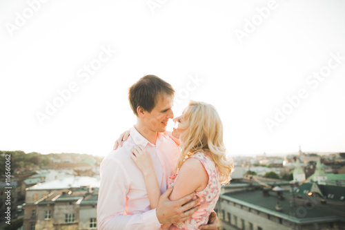 Close up portrait of happy smiling couple in love posing on roof with big balls. Landscape  city © olegparylyak