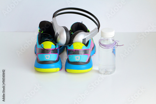 Run shoes, bottle of water and headphones ready for running workout. White background.