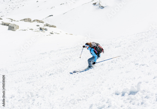 Female skier tackling a steep slope.