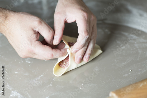 The process of sculpting meat dumplings. The chef cook dinner with dough and flesh stuffing. 