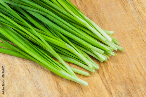 green onions on a wooden chopping board