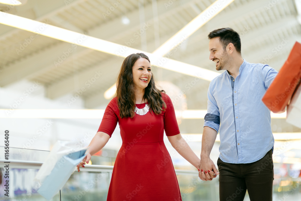 Obraz premium Happy shopper couple buying clothes