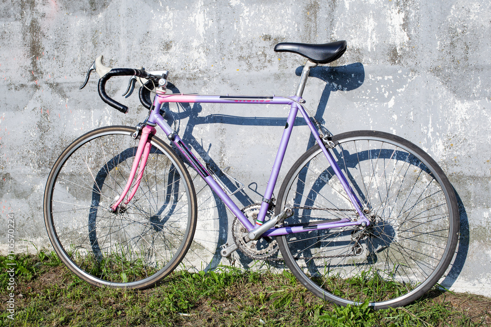 Lilac sports bike standing near gray wall Lilac sports bike standing near gray wall