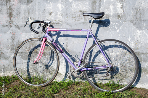 Lilac sports bike standing near gray wall