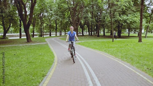 Wallpaper Mural Young beautiful girl riding a bicycle in a summer park Torontodigital.ca