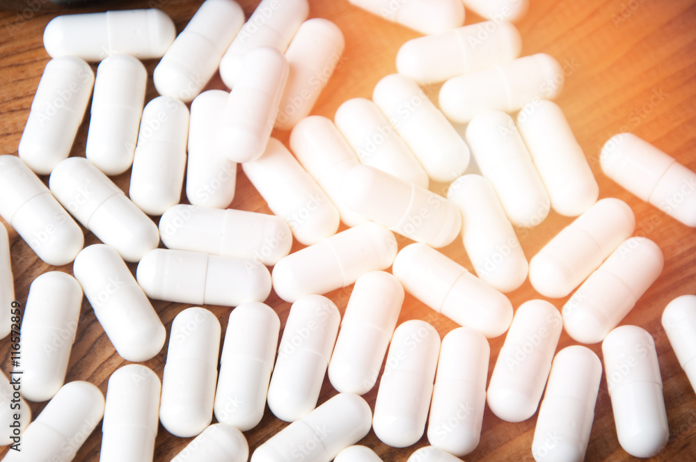 Creatine tablets on a wooden table Creatine tablets on a wooden table