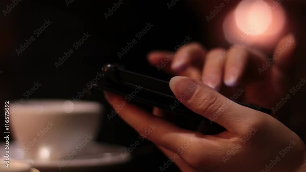 female hands using a smartphone in the cafe and the waitress brings the order female hands using a smartphone in the cafe and the waitress brings the order