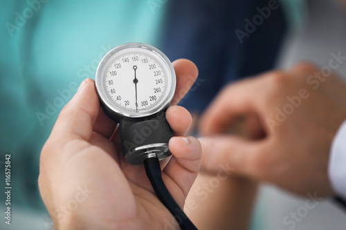 Male hand holding medical manometer and measuring blood pressure