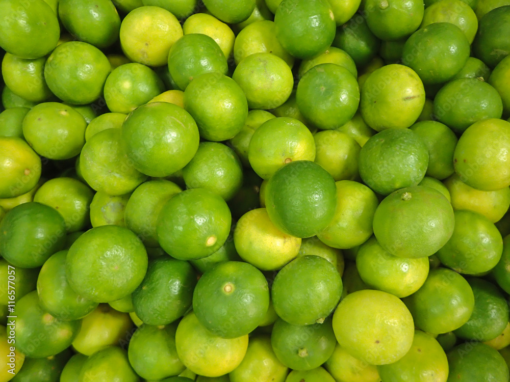 Group of green and yellow lemon on the background