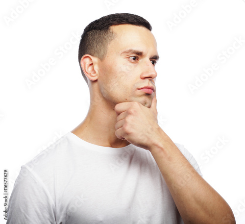 Portrait of handsome young thoughtful man isolated over white ba