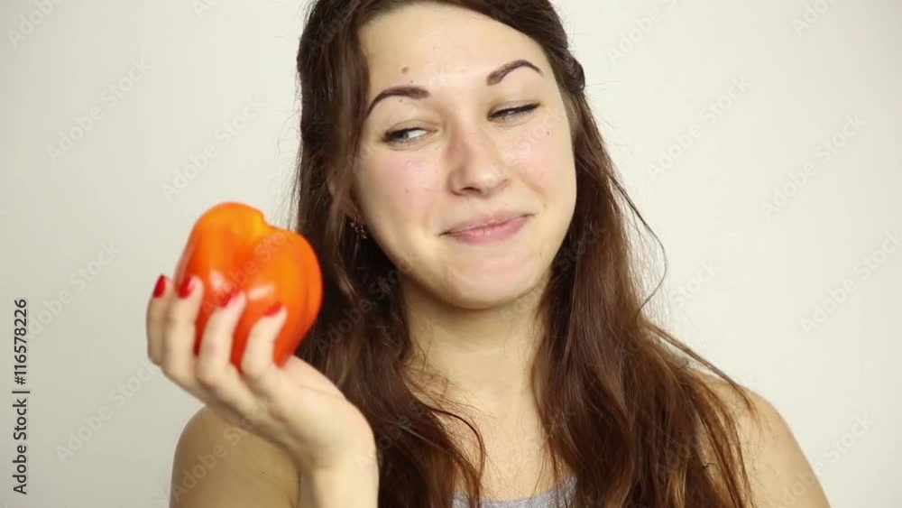 beautiful young woman eating an vegetables. holding a red pepper. healthy food - healthy body concept beautiful young woman eating an vegetables. holding a red pepper. healthy food - healthy body concept
