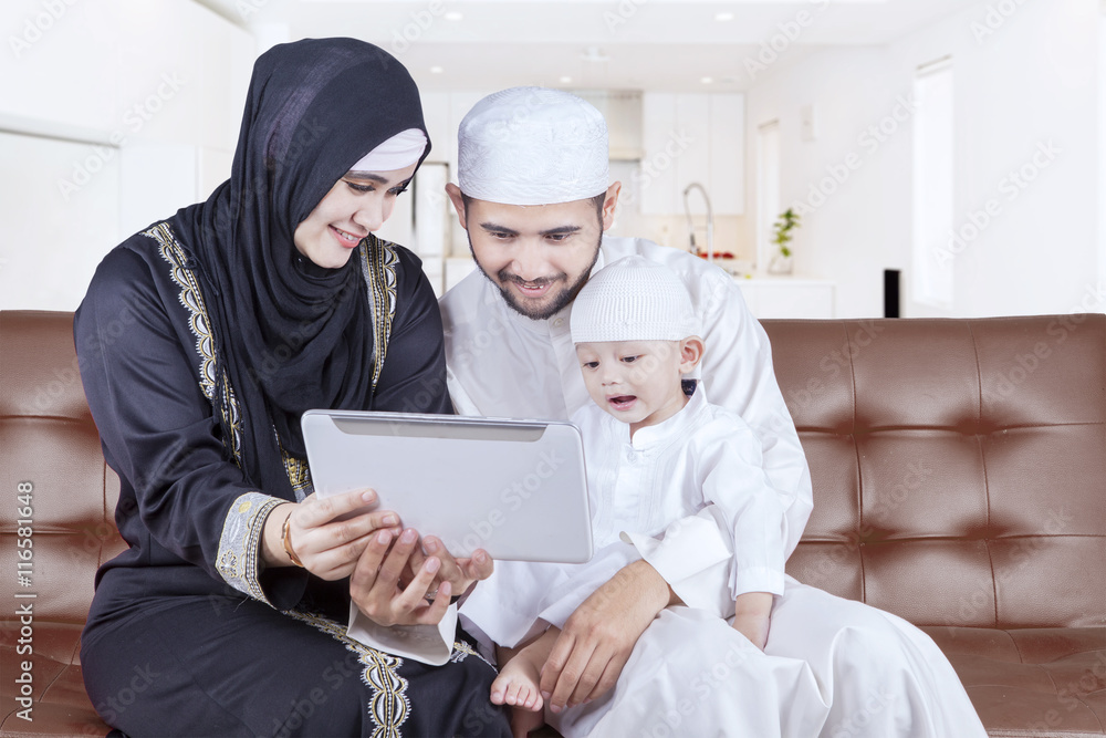 Arabian family playing tablet on sofa Arabian family playing tablet on sofa
