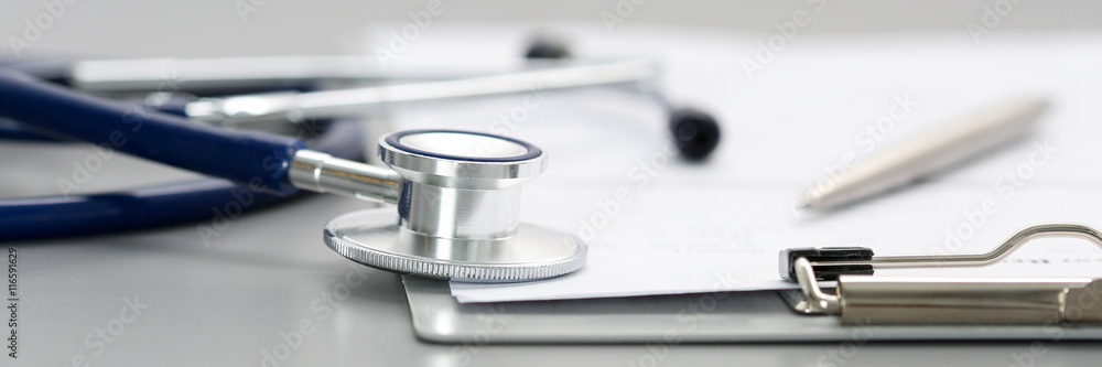 Stethoscope head lying on medical form on clipboard pad - obrazy, fototapety, plakaty 